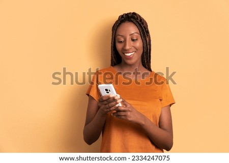 happy black young woman checking smartphone  in all beige colors. app, social media, addiction, network concept.