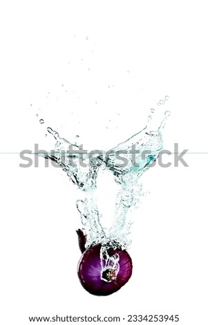 An Onion falling into water splash on a white background