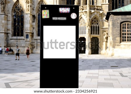 billboard on busy street. blank white poster and advertiser ad space. digital outdoor display lightbox. base for mockup. empty glass display panel. soft streetscape. stone church facade background