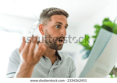 A Worried middle-aged man reading unexpected paper document. Royalty-Free Stock Photo #2334262451