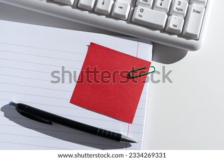 Sticky Note With Message Clipped On Opened Notebook On Desk With Pen And Keyboard. Information Presented On Memo Attached On Notepad Next To Pencil.