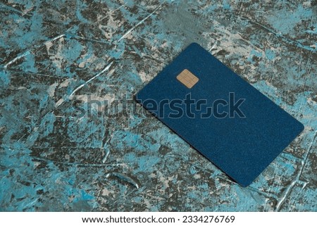 Modern bank credit card with chip on dark background.
