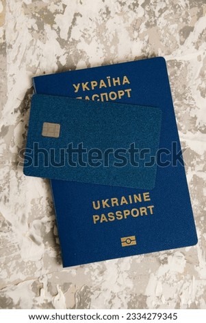 Passport of a citizen of Ukraine and a modern credit bank card with a chip on a light table. The concept of increasing cases of fraud in Ukraine