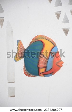 Ornament of colored fish on a white wall, hotel