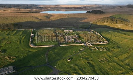 An aerial view of the remains of an auxiliary fort on Hadrian's Wall,  Housesteads Roman Fort, in Northumberland, England,in a middle of a green field Royalty-Free Stock Photo #2334290453