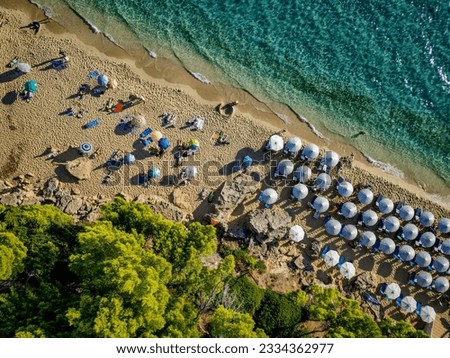 4K Diagonal Drone shot of Makris Gialos beach, Kefalonia, Cephalonia, Greece with the sea, people lounging under umbrellas and greeneryrocky,landscape