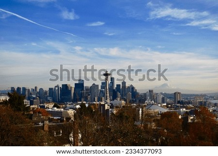 An aerial shot of the Space Needle in Seattle with Mount Rainier in the background