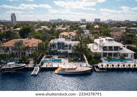 Aerial drone Shoot in Florida, USA, commercial area, luxury houses, buildings and mansions, abundant tropical vegetation around, blue sky and Ocean.