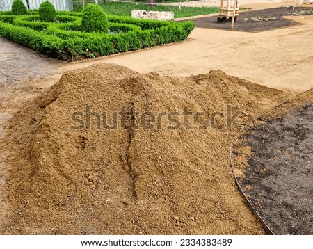 beige fine fraction of gravel is used for the construction of park paths and courtyards. natural sand-like material is rolled or compacted by vibrating rammers Royalty-Free Stock Photo #2334383489