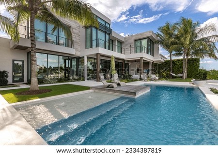 Florida, USA. Modern building with swimming pool, trees, chairs. Urban landscape with blue reflecting pool, city architecture, and scenic environment. Royalty-Free Stock Photo #2334387819