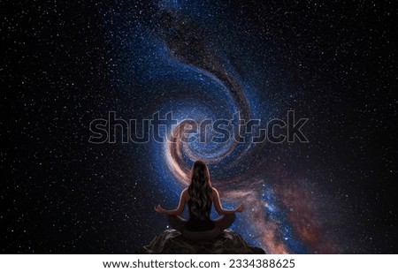 Woman meditating in front of the universe