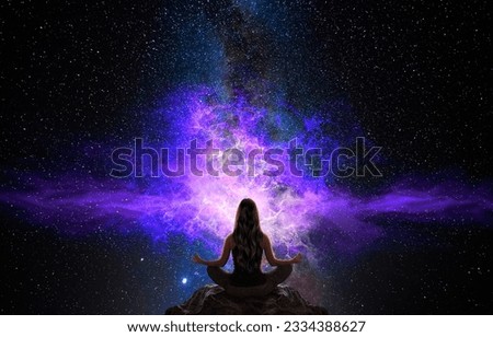 Woman meditating in front of the universe Royalty-Free Stock Photo #2334388627
