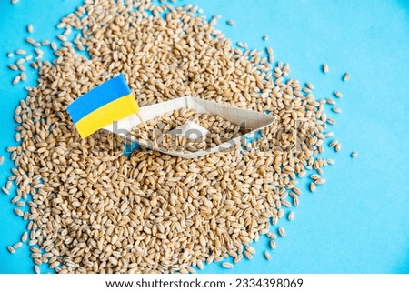 Ukrainian ship grain wheat and spikelets on a blue background. Ukraine Russia conflict,  Grain deal and problem of blockade of ports, grain corridor Royalty-Free Stock Photo #2334398069