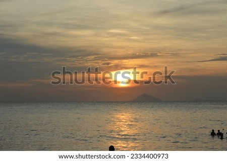 sunset in anyar beach with mount anak karakatau in horizon.