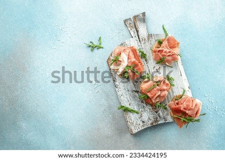 sandwich with jamon ham, arugula on a wooden board. Fresh sandwich Toast tapas. banner, menu, recipe place for text, top view.
