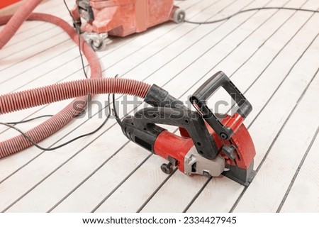Construction worker cuts concrete floor for electrical cable, builder uses circular saw with diamond crown. Install underfloor heating. Royalty-Free Stock Photo #2334427945