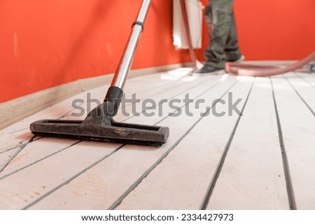 Construction worker use vacuum cleaning concrete floor for Install underfloor heating electrical cable. Royalty-Free Stock Photo #2334427973
