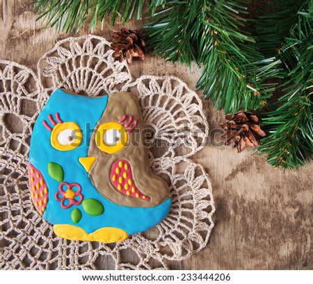 Christmas homemade gingerbread cookie in the form of an owl on a wooden background, selective focus, space for text. Toned