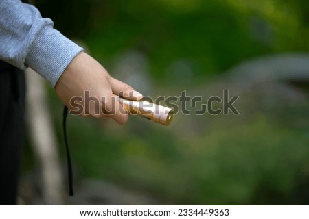 The child shines with a laser pointer with a green beam. Dazzle with a laser. Royalty-Free Stock Photo #2334449363