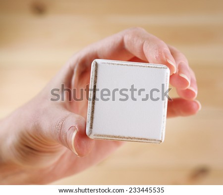 Educational cube in hand, on wooden background