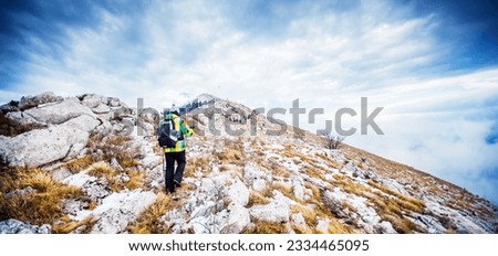 Hikers trekking in a winter landscape amidst snow covered mountains enjoying nature and outdoor endurance activity.
