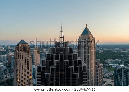 aerial shot of Truist Plaza, Symphony Tower, office buildings and apartments in the city skyline, tower cranes, blue sky and clouds at sunset in Atlanta Georgia USA
