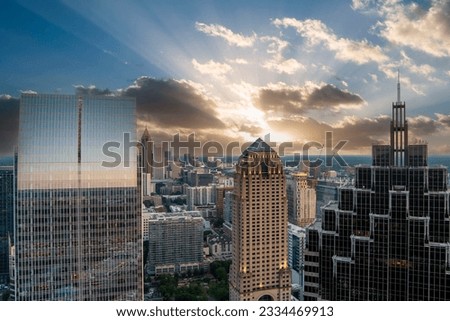 aerial shot of Truist Plaza, Symphony Tower, office buildings and apartments in the city skyline, tower cranes, blue sky and clouds at sunset in Atlanta Georgia USA
