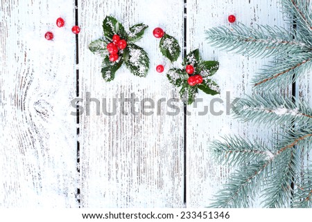Frame with European Holly (Ilex aquifolium) with berries on wooden background