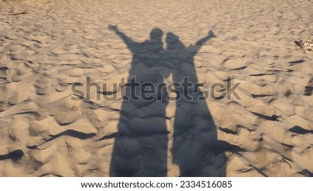 happy silhouettes reflected on the sand 