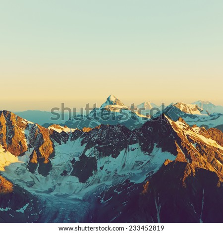 scenic alpine landscape with and mountain ranges. natural mountain background. vintage stylization Royalty-Free Stock Photo #233452819