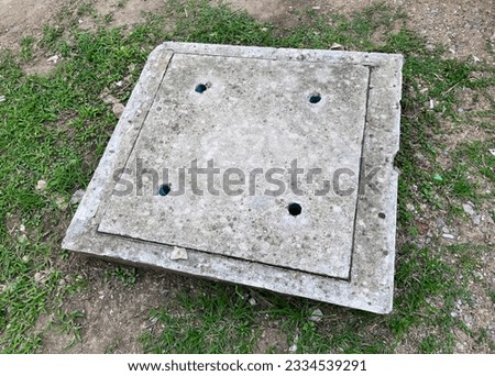 a photography of a concrete box with holes in it on the ground, there is a concrete box with holes in it on the ground.