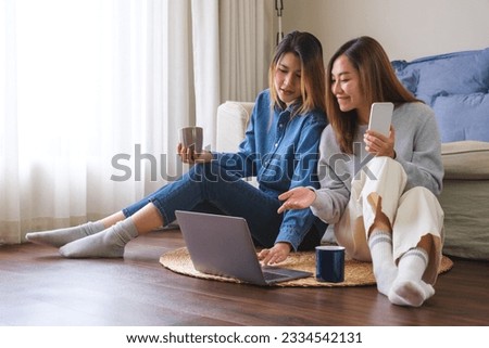 Portrait image of a young couple women using mobile phone and laptop computer together