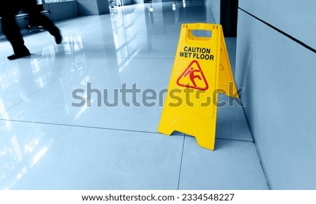 Cleaning and caution wet flooring signboard on the floor Royalty-Free Stock Photo #2334548227