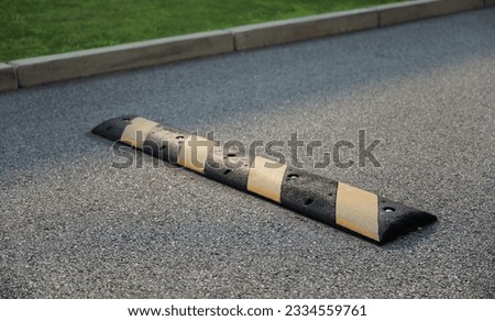speed bump on a street symbolizes traffic control, caution, and slowing down for safety. It represents the need to be vigilant and considerate of others Royalty-Free Stock Photo #2334559761