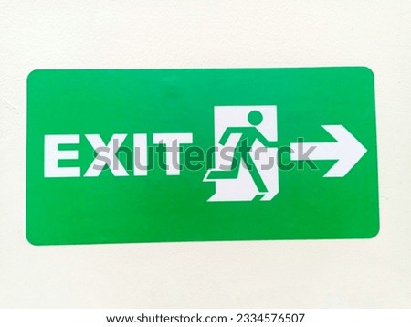 Sign safety exit, on the wall white