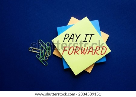 Pay it forward symbol. Concept words Pay it forward on yellow steaky note. Beautiful pink background. Business and Pay it forward concept. Copy space. Conceptual photo