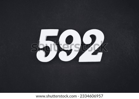 Black for the background. The number 592 is made of white painted wood.