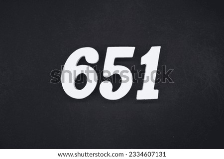 Black for the background. The number 651 is made of white painted wood.
