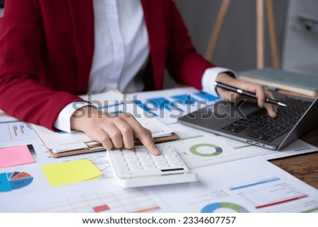 Young Asian happy professional business woman worker employee sit at office desk and working on computer and calculator, Accountant calculation taxes rates firm law account on computer