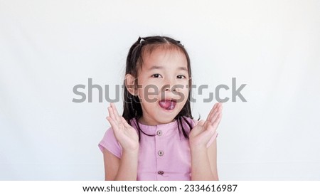 happy surprised beautiful little child girl in casual looking to camera on light color background. Human emotions and facial expression