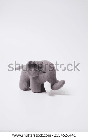  Grey colored toy elephant on a white background                               