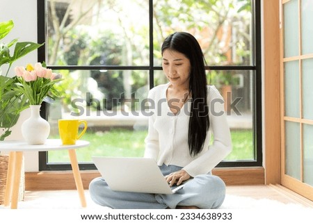 Happy young woman working and meeting online at home.  Lifestyle freelance relax and chill drinking coffee in living room, Nature garden background.  Lifestyle Concept