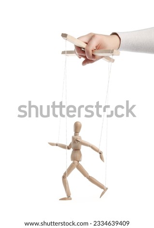 Woman pulling strings of puppet on white background, closeup Royalty-Free Stock Photo #2334639409