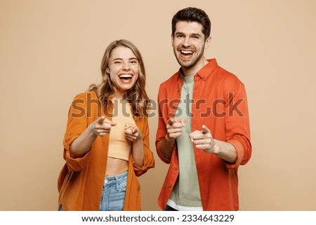 Young fun couple two friends family man woman wear casual clothes point index finger camera on you motivating encourage together isolated on pastel plain light beige color background studio portrait Royalty-Free Stock Photo #2334643229
