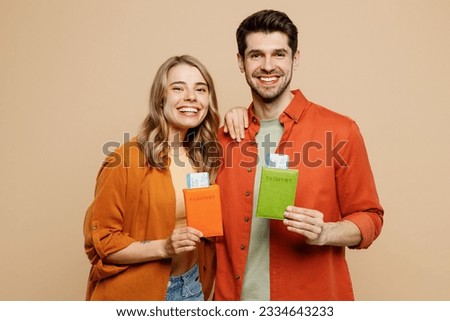 Traveler couple two friends family man woman wear casual clothes hold passport ticket isolated on plain beige background. Tourist travel abroad in free spare time rest getaway. Air flight trip concept Royalty-Free Stock Photo #2334643233