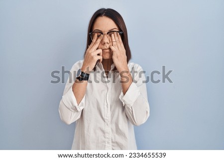 Young hispanic woman standing over white background rubbing eyes for fatigue and headache, sleepy and tired expression. vision problem 