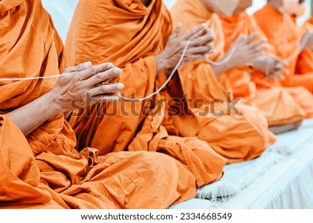 close up monk's hand holding holy thread, buddhist holy day, thai buddhist monk ordination ceremony wallpaper background concept Royalty-Free Stock Photo #2334668549