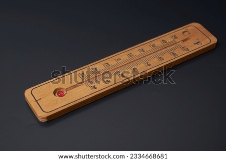 Brown wooden classic thermometer on a black background                               