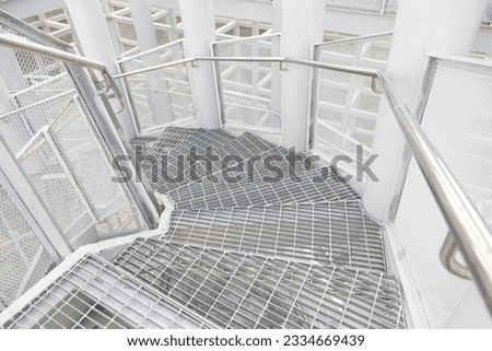 A spiral staircase built entirely of metal structures. Including the area used metal grille painted with metallic gray color.