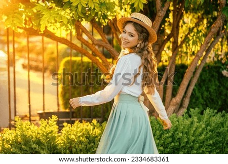 Art portrait happy woman dancing spinning in vintage straw hat on head, girl pretty smiling face red hair fly in wind, retro lady old style white blouse mint skirt. green tree sun light summer nature Royalty-Free Stock Photo #2334683361